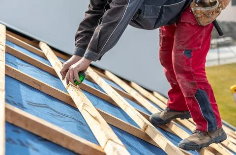 Craftsman or construction worker install a new roof, roofing tools, new metallic Stock Photos