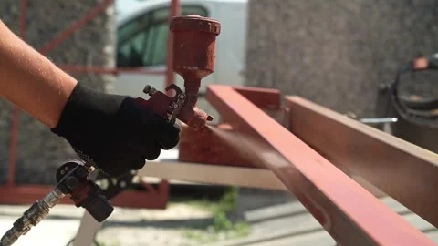 Craftsman paints a metal structure using a spray gun Stock Footage 258645920
