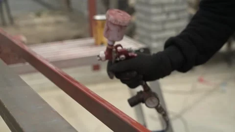Craftsman paints a metal structure using a spray gun Stock Footage 261282257