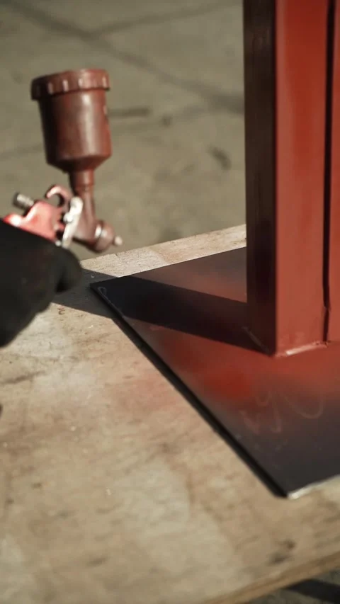 Craftsman paints a metal structure using a spray gun Stock Footage 266805939