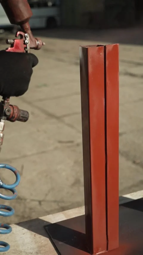 Craftsman paints a metal structure using a spray gun Stock Footage 266806656