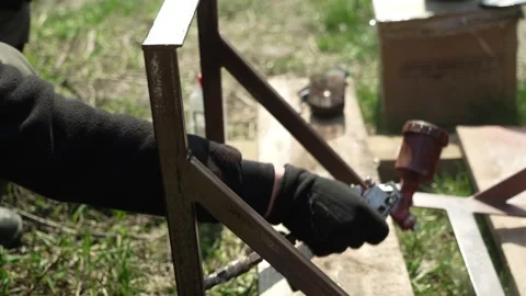 Craftsman paints a metal structure using a spray gun Stock Footage 274530231