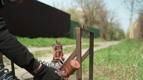 Craftsman paints a metal structure using a spray gun Stock Footage 274530250
