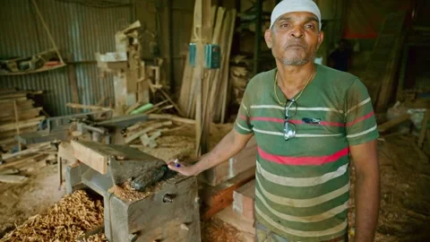 Craftsman points to wood machine inside his studio Stock Footage 308617284