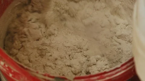 Craftsman prepares liquid mixture for construction work with drill Stock Footage 304409663