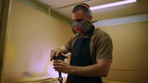 Craftsman preparing paint gun in workshop Stock Footage 308932450