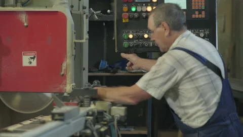 Craftsman Presses Button On Machine Control Panel To Process Lumber With Saw Video stock 232738934