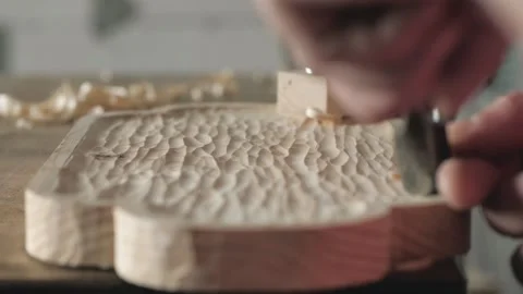 A craftsman processes a pine wood board with a chisel. artisan makes a tea tray Stock Footage 156670643