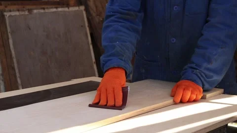 A craftsman processes a wooden board manually using sandpaper Stock Footage 336260016