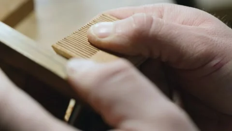 Craftsman processes a wooden comb with a planer. making a wooden beard comb Stock Footage 156670232