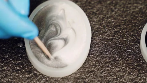 Craftsman in protective gloves creating exclusive natural pattern of mixed epoxy Stock-Footage 265898761