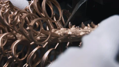 Craftsman in protective gloves cuts off ring blanks from a ring mold close up Stock Footage 127466180