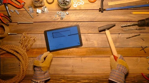 Craftsman remove his working gloves and work with digital tablet. Top view. Stock Footage 70646139