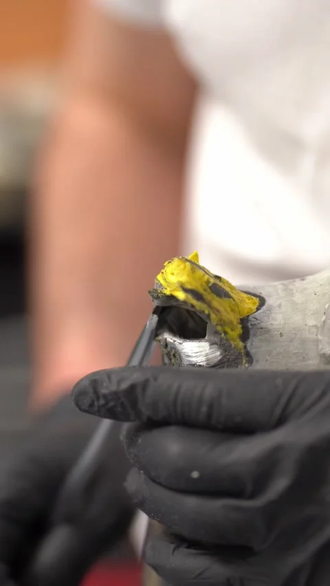 Craftsman removing plastic material from prosthesis in factory. Vertical video Stock Footage 237608042