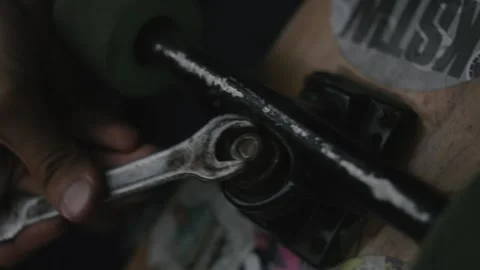 Craftsman repairs the longboard with a wrench to replace kingpin and bushing Stock Footage 163365186