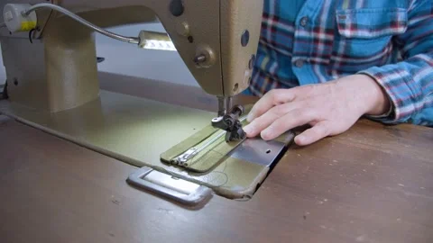 A craftsman sews suede on a sewing machine. A leatherworker sews the zipper. Stock Footage 152185431