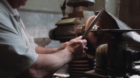 Craftsman sharpening knife in the workshop Stock Footage 75708301