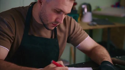 Craftsman sketching design on paper in workshop Stock Footage 308932847