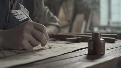 Craftsman sketching flying machine wings with a feather pen on a desk Video stock 340322600