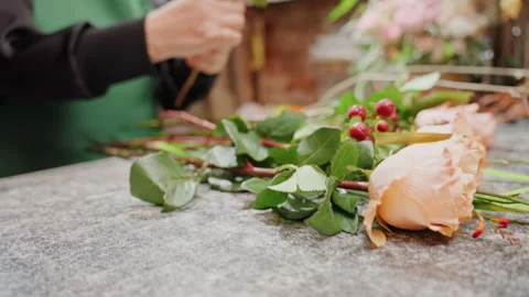 Craftsman skillfully assembles peach roses into bouquet. An experienced florist Stock Footage 331456030