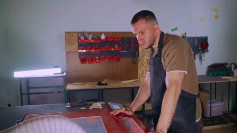 Craftsman smoothing red plastic in his workshop Video stock 308932140