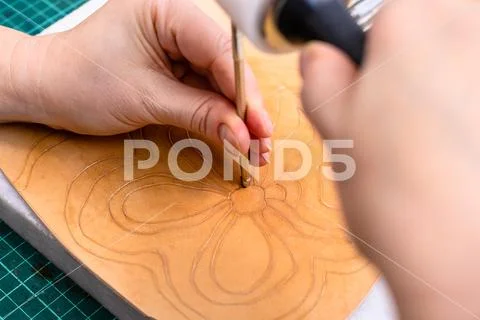 Craftsman stamps the floral pattern on leather Stock Photos
