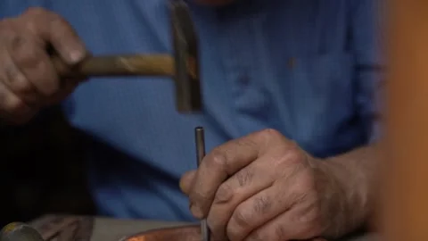 Craftsman strikes patterns on copper vessels with a hammer in his hand Video stock 329392874