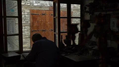 Craftsman strikes patterns on copper vessels with a hammer in his hand Video stock 329392887