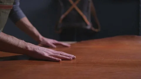 A craftsman touching a big piece of leather on the table slow motion Stock Footage