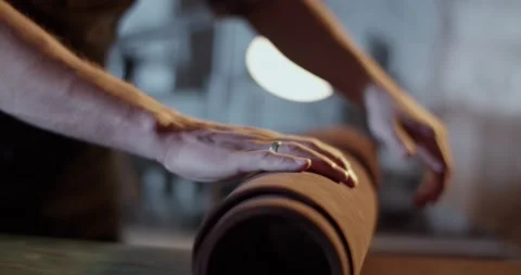 Craftsman unrolling leather on workbench Stock Footage 172490022