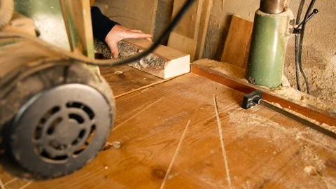 Craftsman uses a circular saw to make a cut to a piece of rough wood in his home Video stock 101008383