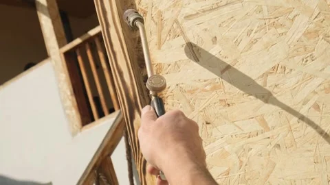 Craftsman uses gas flame torch to decorate wooden elements in furniture and home Stock Footage 332875556