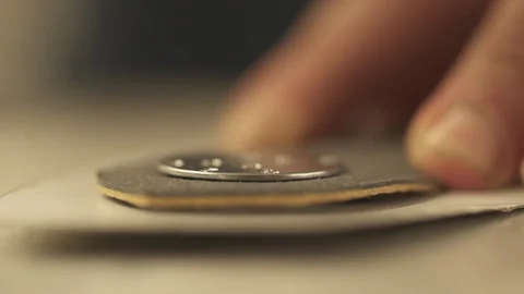 A craftsman uses a hammer and rivets to attach a metal decoration to the leather Stock Footage 266140830