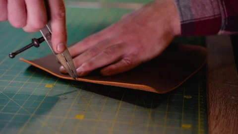 Craftsman Using a Compass to Mark Leather for Precise Cutting Stock Footage 296237548