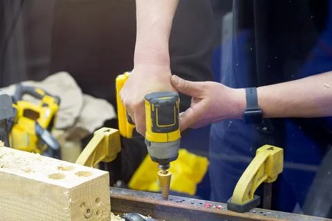 Craftsman using cordless screwdriver with step drill bit to drill metal Stock Photos