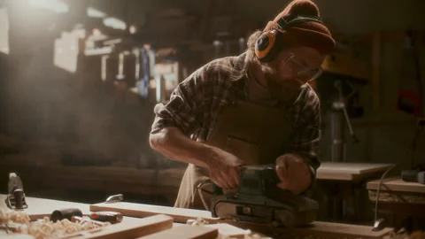 Craftsman Using Electric Belt Sander to Smooth Wooden Board in Workshop Video stock 331983886