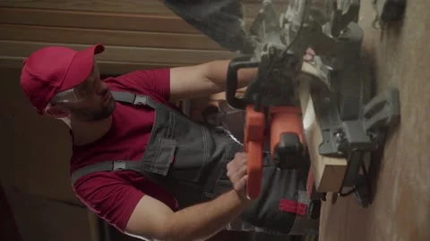Craftsman using a miter saw for precision woodworking in a workshop 스톡 동영상 281673063