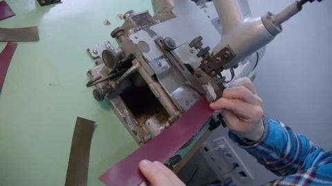 Craftsman using an old-fashioned automatic leather skiving machine. Stock Footage 152185406