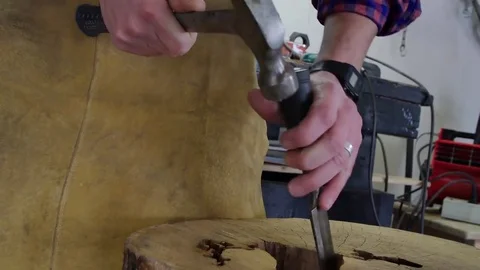 Craftsman welder uses a hammer to make handmade furniture at his workbench Video stock 76991808