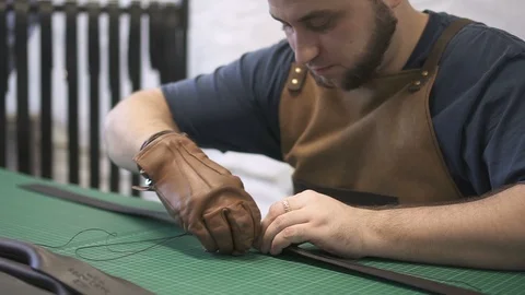 Craftsman working on the black bag handle made with artificial leather in Stock Footage 94534347