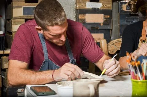 Craftsman working with clay and using pottery tools in workshop Stock Photos