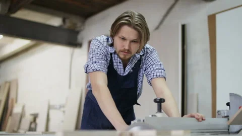The craftsman is working on electric saw machine in a furniture factory Stock Footage 106555535