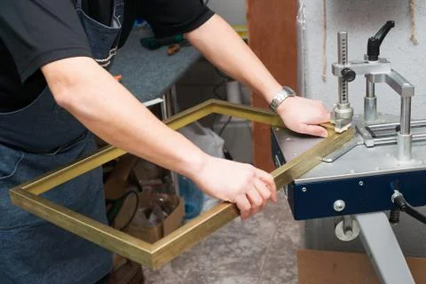 Craftsman working on frame in frameshop. Stock Photos