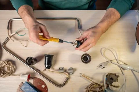 Craftsman working with screwdriver tool on disassembling light bulb socket part 스톡 사진