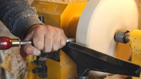 Craftsman works with workpiece in workshop. Stock Photos