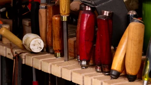 Craftsman's Hand Placing Chisel into Tool Slot on Workbench Stock Footage 306732694