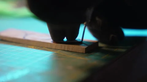 Craftsman's hands in black gloves applying glue to a small wooden piece Stock Footage 335464458