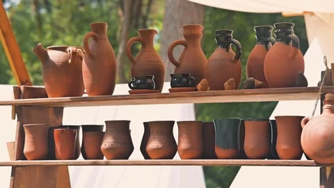 Craftsmen work on pottery, shaping clay into jugs and bowls at a historical Vídeo Stock 345031211