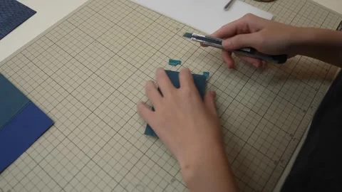 Craftsperson trims excess leather corner using small blade tool Stock Footage 339642825