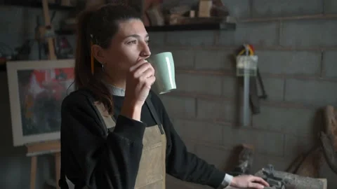 Craftswoman drinking coffee in workshop Stock Footage 167422572